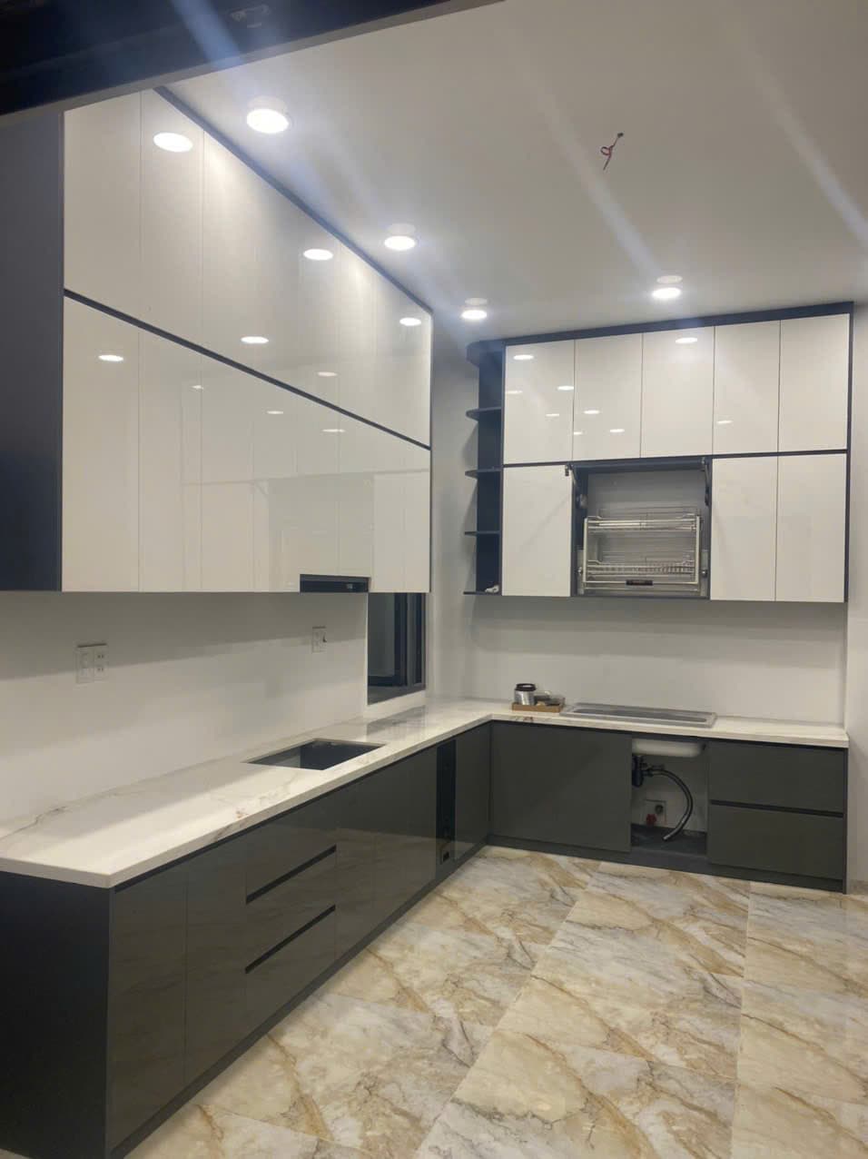 Tủ bếp Acrylic trắng xám chữ L lắp đặt cho căn hộ chung cư hiện đại