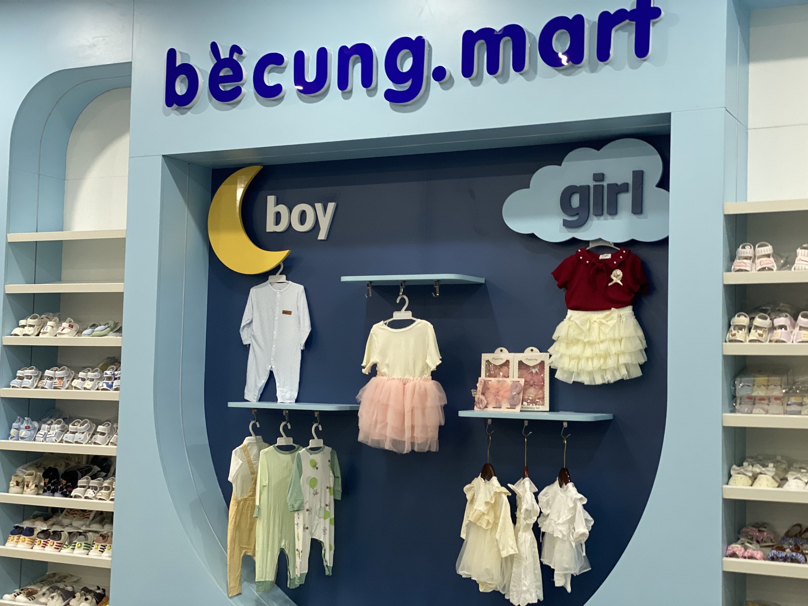 Vách logo và khu trưng bày trang phục trẻ em trong cửa hàng bé cưng.mart
