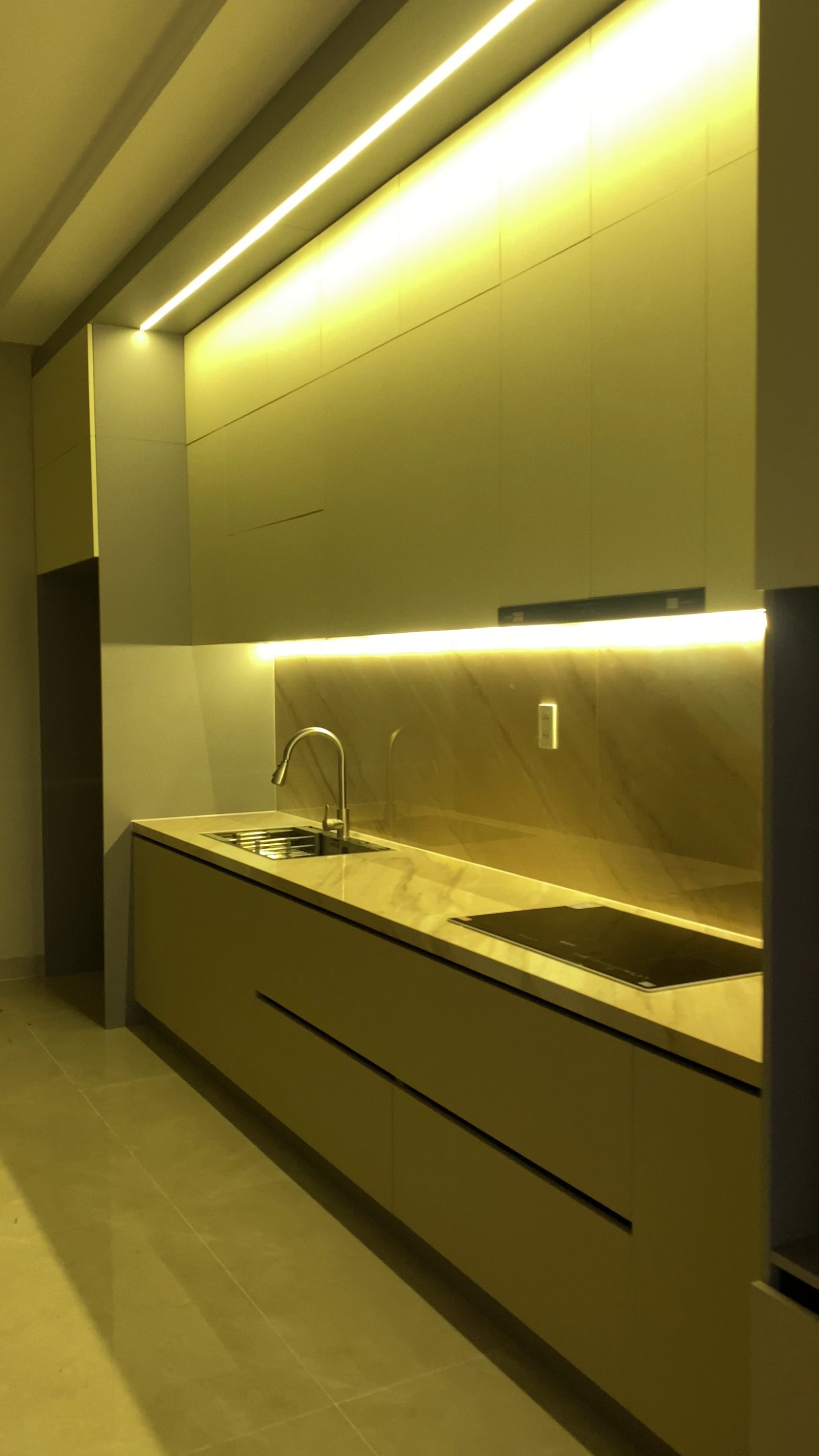 Khu bếp hoàn thiện với đèn LED hắt và hệ tủ phẳng tại nhà chị Hiếu