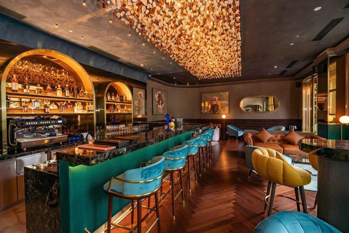 Khu bar khách sạn Movenpick với dãy ghế cao, quầy bar và ánh sáng trần giàu trải nghiệm
