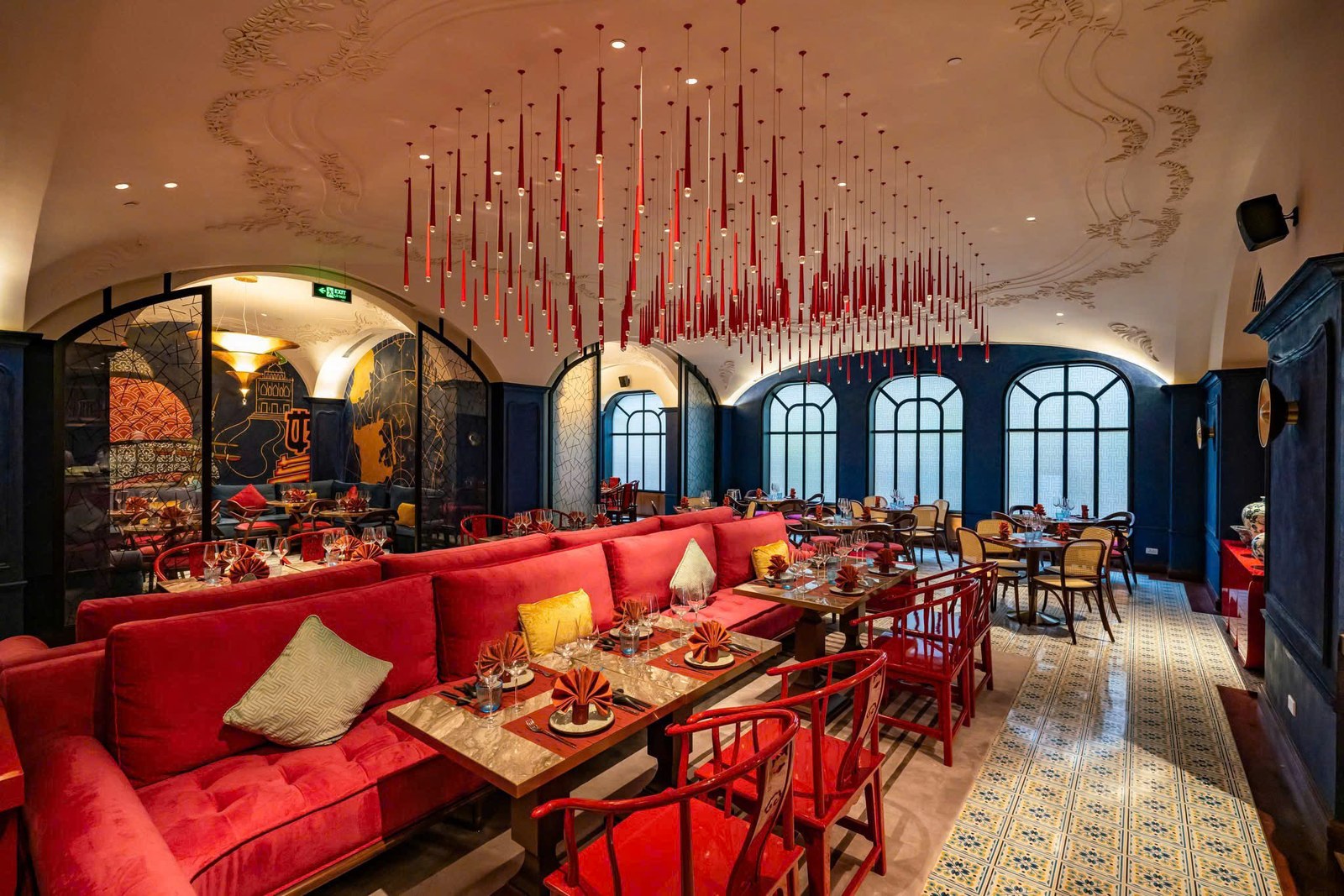 Không gian nhà hàng khách sạn Movenpick với nội thất đỏ, xanh đậm và đèn thả tạo điểm nhấn mạnh