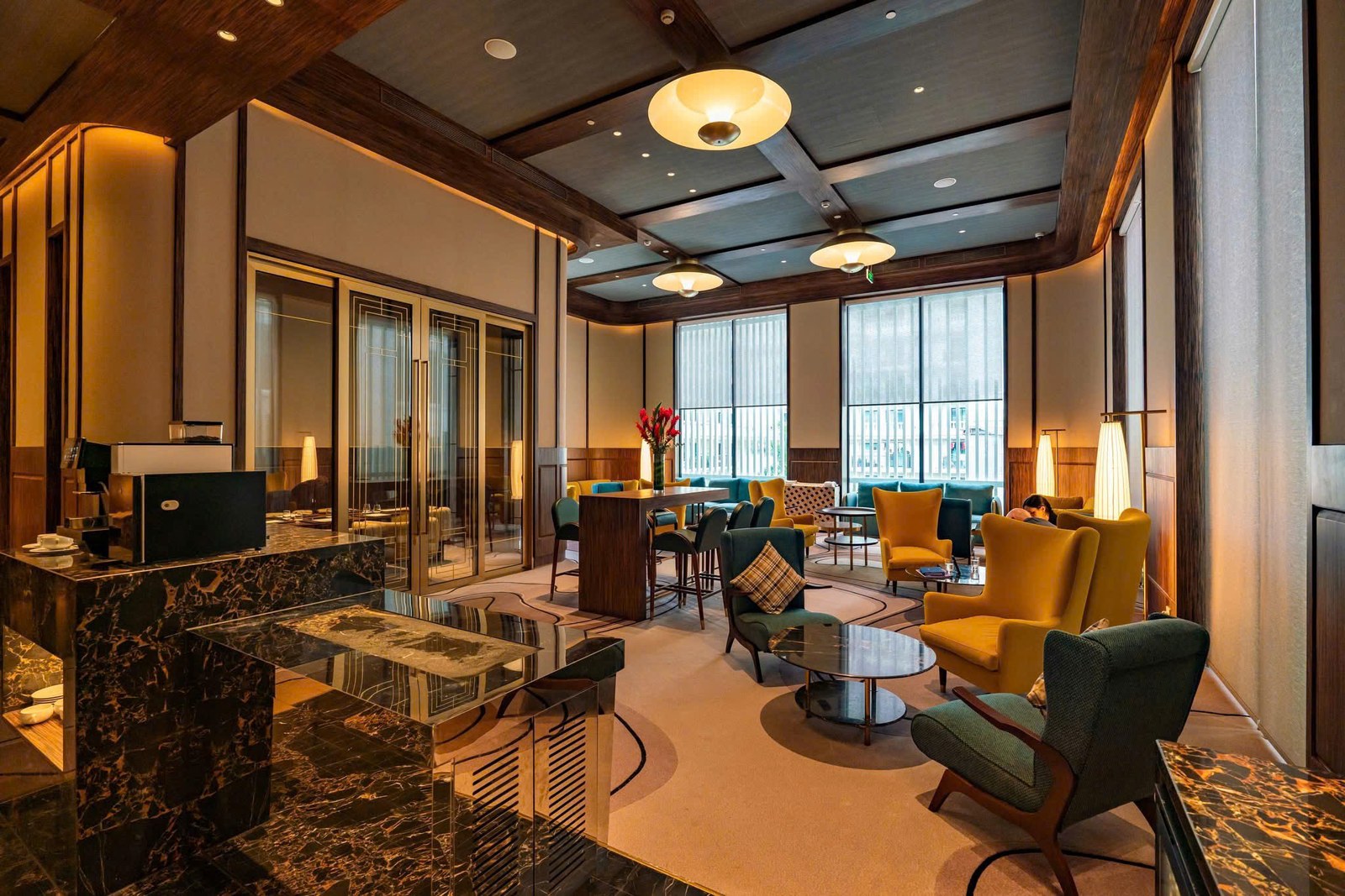 Sảnh đón tiếp khách sạn với bố cục sang trọng, ánh sáng vàng ấm và khu vực tiếp khách