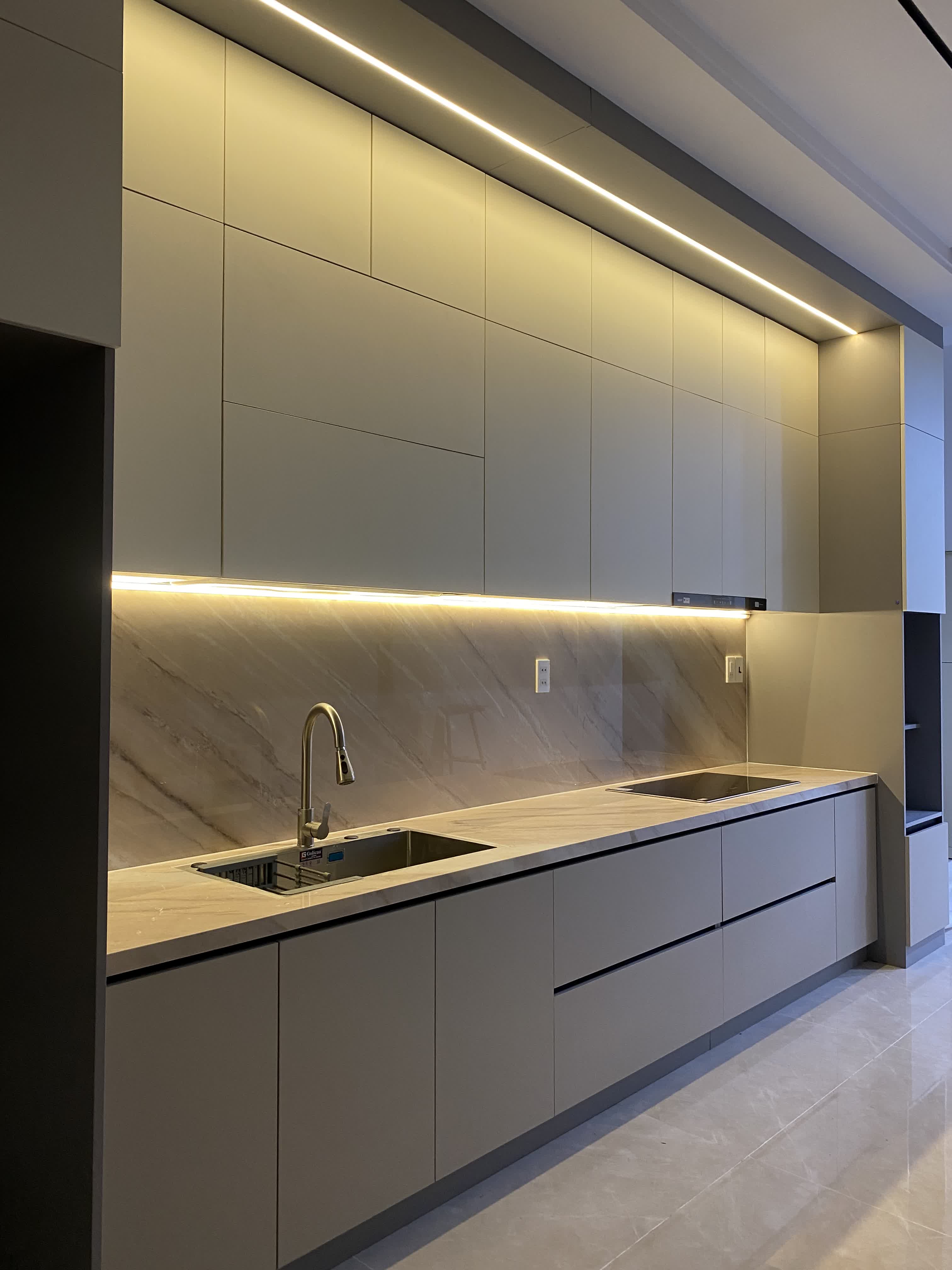 Mặt đá, đèn led và khu nấu tạo cảm giác hoàn thiện cao cho tủ bếp căn hộ
